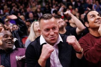 Georges St-Pierre wraps the belt around the waist of the UFC 315 main event winner