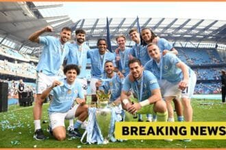 Manchester City players celebrate with the Premier League trophy