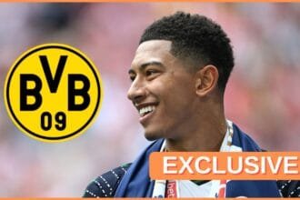 Jobe Bellingham smiles at Dortmund club crest.