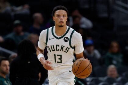 Milwaukee Bucks No. 13 Ryan Rollins dribbles up the court during a preseason game against the Detroit Pistons at Fiserv Forum.
