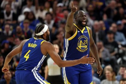 Golden State Warriors Draymond Green #23 and Moses Moody #4 react after forcing a turnover in the second half against the Memphis Grizzlies at Chase Center.