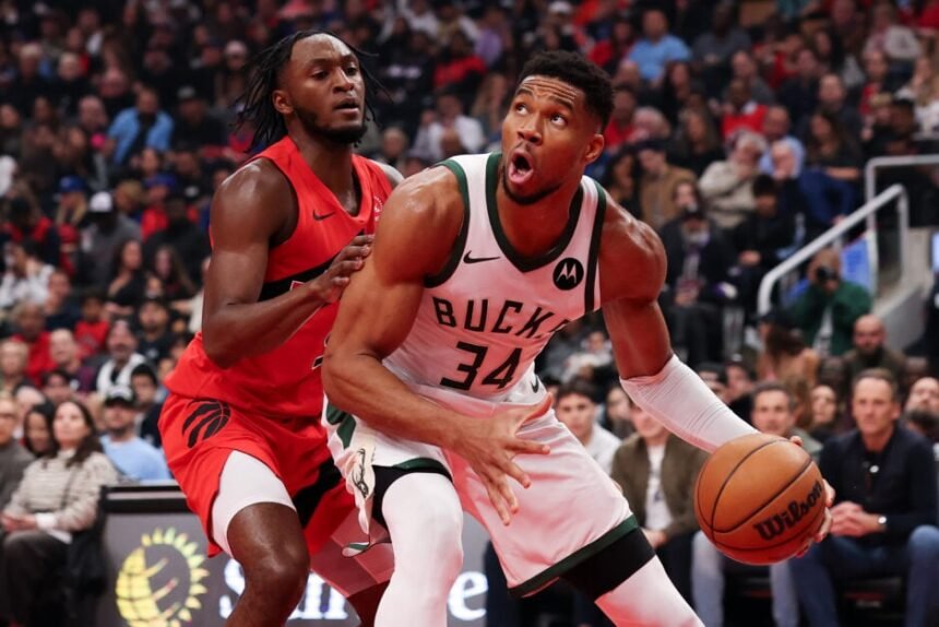 Giannis Antetokounmpo #34 of the Milwaukee Bucks controls the ball with #5 Immanuel Quickley of the Toronto Raptors during the first half at Scotiabank Arena.