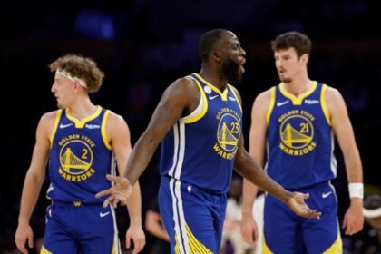 Draymond Green #23 of the Golden State Warriors reacts to an offensive foul in front of Brandin Podzemski #2 and Quinten Post #21 during the Warriors' 119-109 win in the season opener between the Golden State Warriors and the Los Angeles Lakers on October 21, 2025 at Crypto.com Arena in Los Angeles, California.