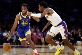 LJ Cryer #18 of the Golden State Warriors controls the ball with #9 Bronny James of the Los Angeles Lakers during the second half at Crypto.com Arena.