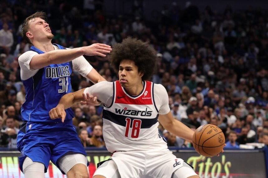 Cooper Flagg #32 of the Dallas Mavericks is fouled by Kyshawn George #18 of the Washington Wizards.