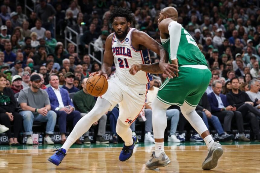 Joel Embiid #21 of the Philadelphia 76ers dribbles while being guarded by Xavier Tillman #26 of the Boston Celtics during the first quarter of a game at TD Garden.