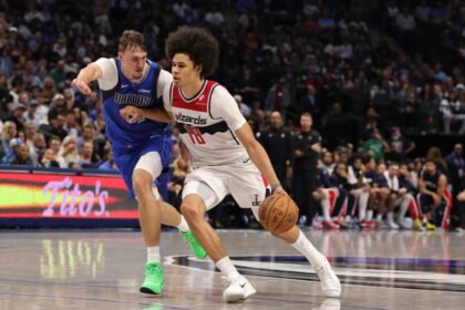 Kyshawn George #18 of the Washington Wizards is defended by Cooper Flagg #32 of the Dallas Mavericks during the second half at American Airlines Center.