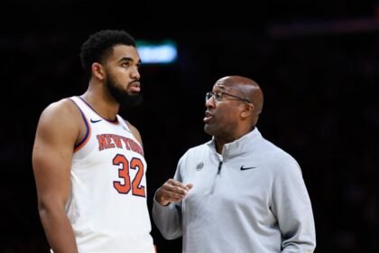 Karl-Anthony Towns #32 of the New York Knicks speaks with head coach Mike Brown.