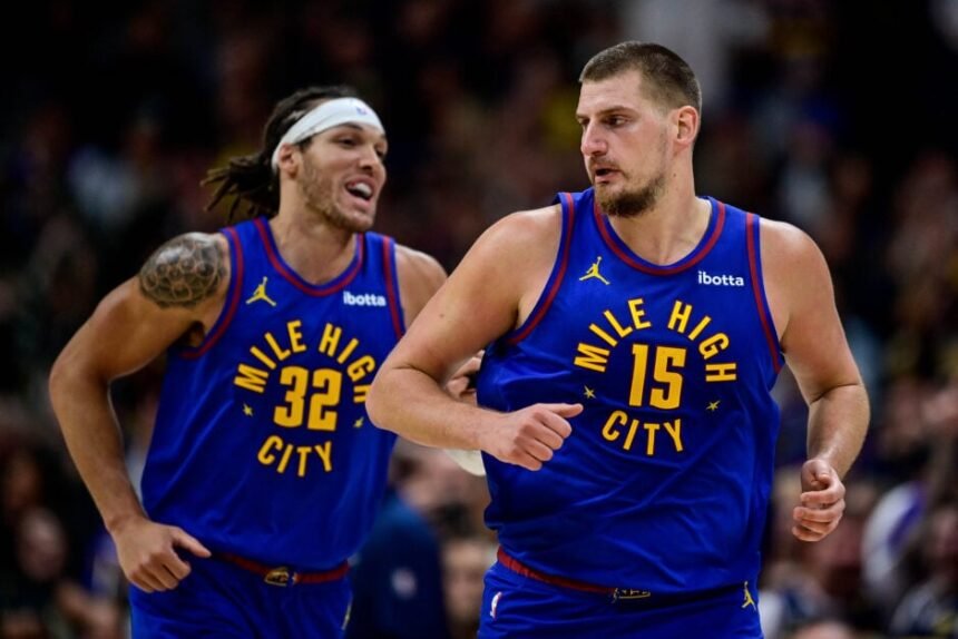 Nikola Jokic #15 and Aaron Gordon #32 of the Denver Nuggets celebrate hitting shots in the second half of the game against the Utah Jazz at Ball Arena.