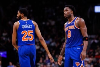 Mikal Bridges #25 and OG Anunoby #8 of the New York Knicks react during the first half of an NBA game against the Toronto Raptors at Scotiabank Arena on December 9, 2024 in Toronto, Canada.
