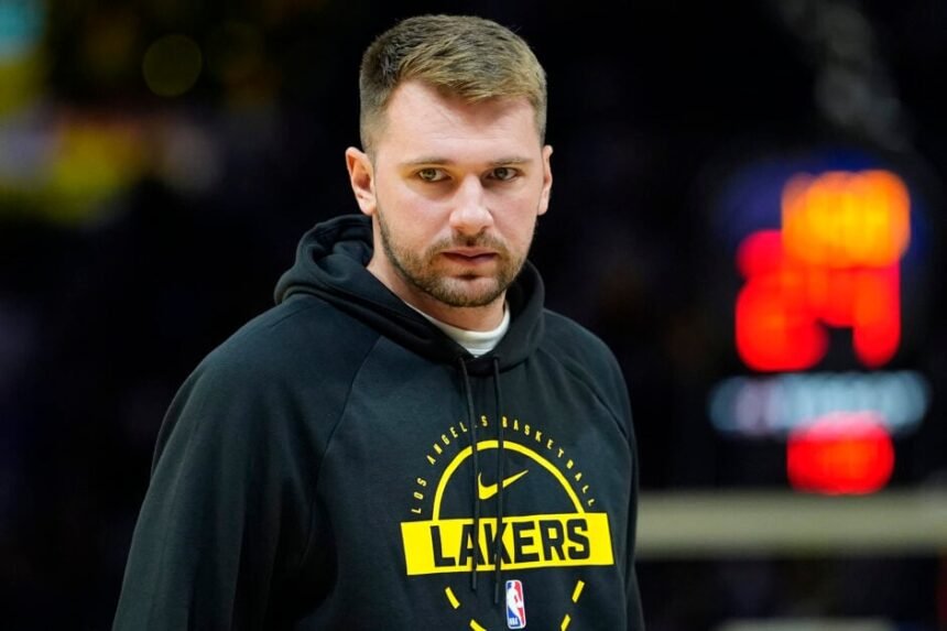 Los Angeles Lakers #77 Luka Doncic watches the game against the Golden State Warriors in streetwear.