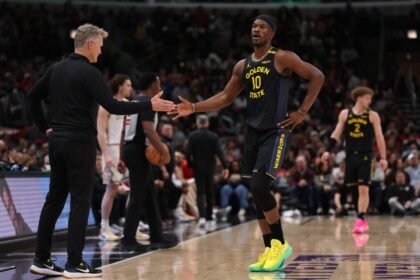Golden State Warriors head coach Steve Kerr high-fives Jimmy Butler #10 during the second half of the game against the Chicago Bulls at the United Center.