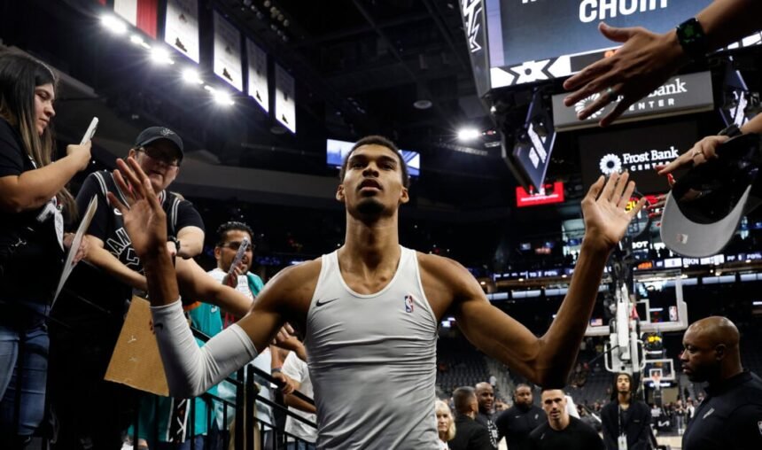 Victor Wenbanyama high-fives a fan before the match