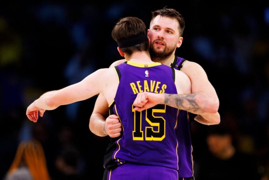 Los Angeles Lakers #77 Luka Doncic hugs Austin Reeves Los Angeles Lakers #15 watches the second half of the game against the Houston Rockets at Crypto.com Arena.