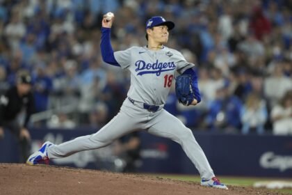 Yoshinobu Yamamoto picks up trash in the Dodgers dugout after pitching a complete game in the World Series