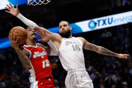 No. 12 Jay Morant of the Memphis Grizzlies goes to the basket while guarded by Caleb Martin of the Dallas Mavericks during the second half at American Airlines Center on March 7, 2025 in Dallas, Texas.